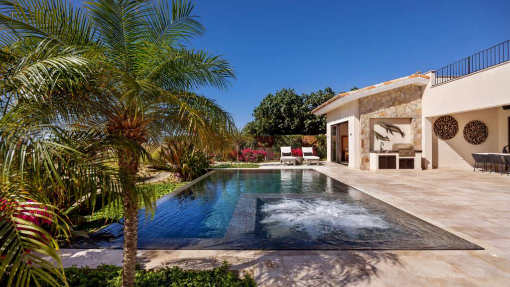 Los Cabos Los Valles Sophisticated and solidly built, this 5,588 sq.ft. estate in Club Campestre offers luxury living with exceptional construction quality rarely found in Los Cabos. Residents enjoy exclusive access to a private beach club and world-class golf course, all just minutes from San Jose vibrant dining and culture. The home features 4 ensuite bedrooms, a 3-stop elevator, and a Generac backup system. Entertain in style with a chef's kitchen, wine room with Tzalam wood cabinetry, and an outdoor BBQ area with fire pit. Relax by the heated pool or on the Jacuzzi terrace with partial ocean – Costa Villa 103, C. Barrancas, Cabo San Lucas, BS